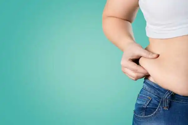 Image of woman pinching her love handles to show weight gain Trowbridge